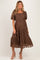 woman wearing a brown lace maternity dress with short puff sleeves and a flowing skirt, highlighting her baby bump