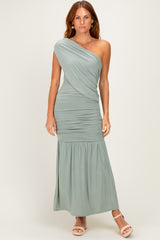 woman wearing a sage green one-shoulder maxi dress with ruching and a flowy bottom
