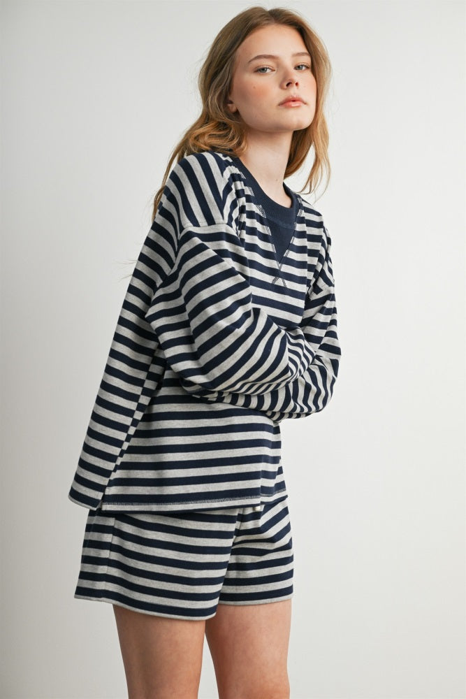 woman wearing a navy and white striped long sleeve top and matching shorts with a relaxed fit