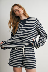 woman wearing a navy and gray striped long sleeve top with matching shorts and a drawstring waist