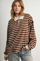 woman wearing a brown and cream striped long sleeve polo top with buttons and relaxed fit, paired with light blue jeans