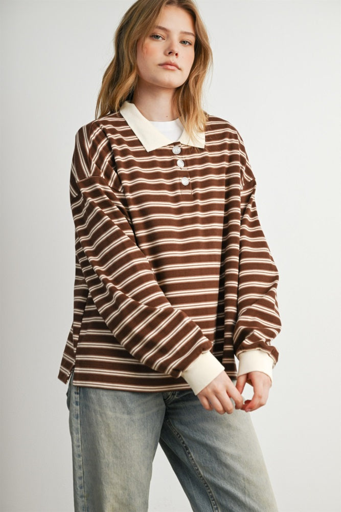 woman wearing a brown and white striped long sleeve collared shirt with buttons and light wash jeans