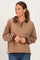 woman wearing a brown and tan striped pullover with a zip neckline and contrast collar, smiling at the camera