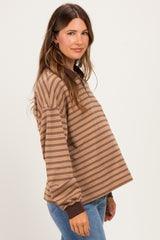 woman wearing a brown striped maternity top with long sleeves and relaxed fit, showing a baby bump