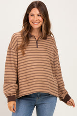 woman wearing a brown striped maternity pullover with a quarter zip and relaxed fit, smiling at the camera