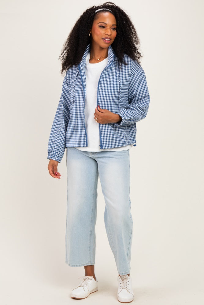 woman wearing a blue and white gingham check puffer jacket, white t-shirt, light wash wide-leg jeans, and white sneakers