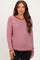 woman wearing a burgundy and white striped maternity sweater with long sleeves and a relaxed fit