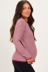 woman wearing a red and white striped long sleeve maternity top, showing her baby bump