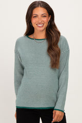 woman wearing a green and white striped maternity sweater with a relaxed fit and a rounded hem