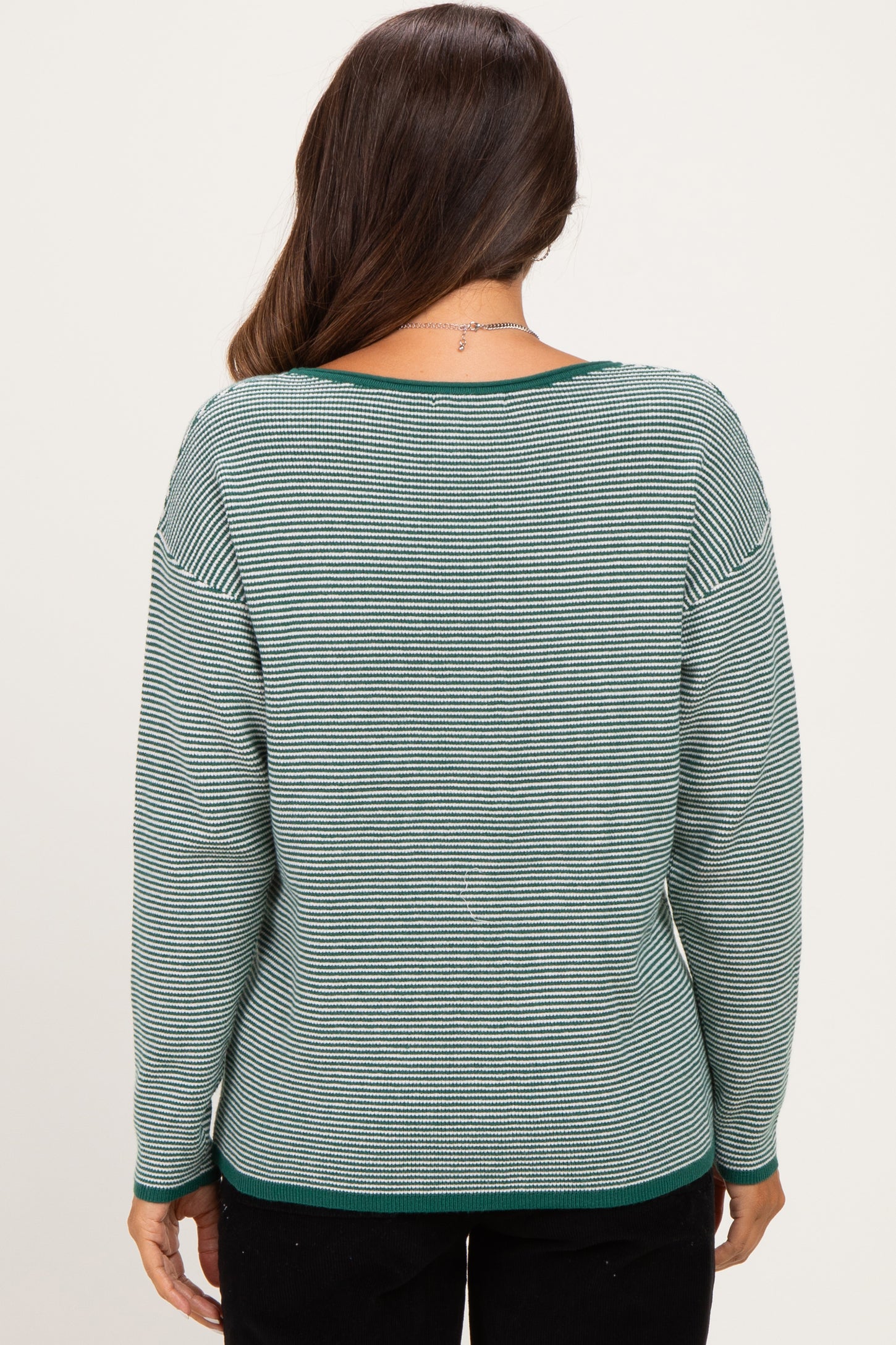 woman wearing a green and white striped maternity sweater, back view, with a relaxed fit and scoop neckline