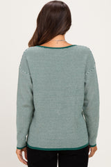 woman wearing a green and white striped maternity sweater, back view, with a relaxed fit and scoop neckline