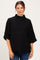 woman wearing a black maternity top with a high neckline and loose sleeves, showing her baby bump