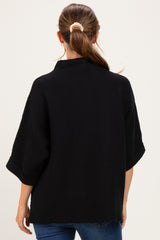 woman wearing a black maternity top with a relaxed fit and three-quarter sleeves, viewed from the back