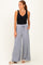 woman wearing a black tank top and light gray wide-leg pants with a drawstring waist and pockets