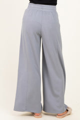 woman wearing light gray wide-leg sweatpants, seen from the back, with an elastic waistband and relaxed fit