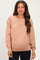woman wearing a soft pink maternity sweater with a relaxed fit and a visible baby bump