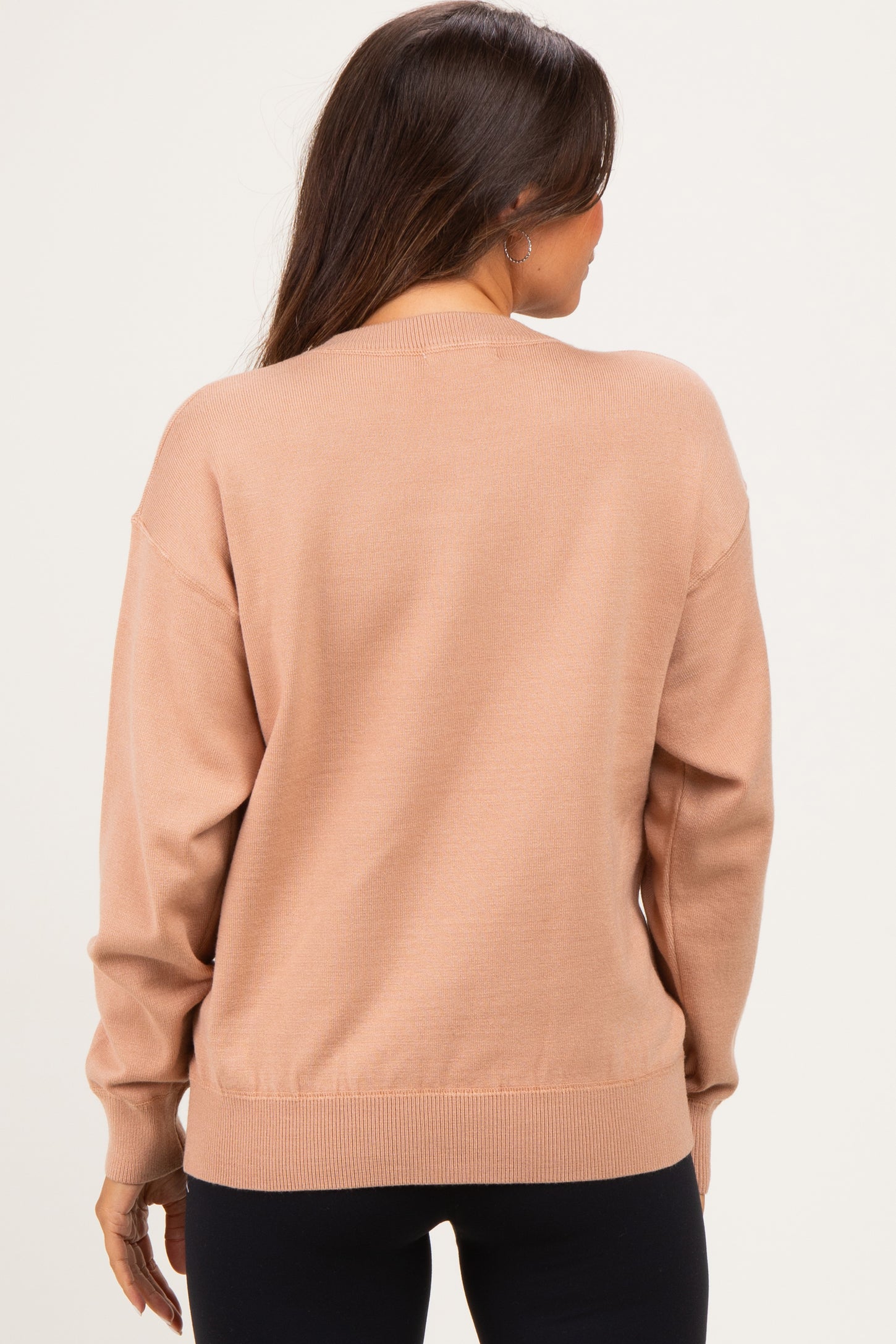 woman wearing a light brown maternity sweater from the back, featuring a relaxed fit and ribbed cuffs