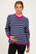 woman wearing a navy and white striped maternity sweater with pink accents and holding her baby bump