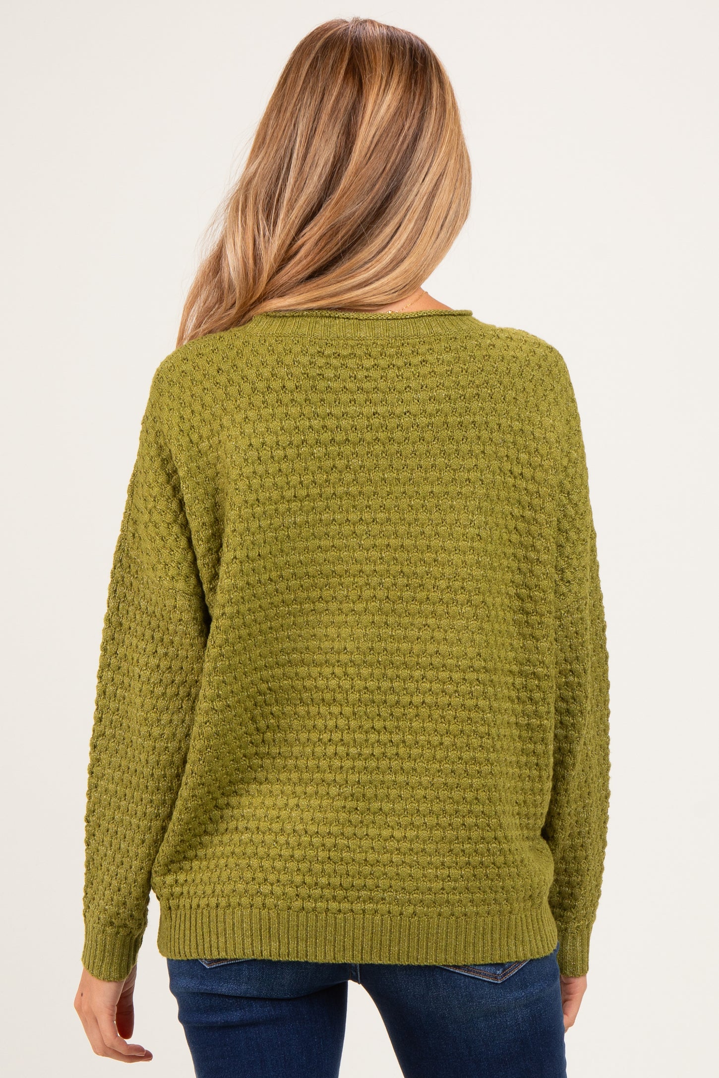 woman wearing a textured olive green maternity sweater, shown from the back with relaxed fit and long sleeves