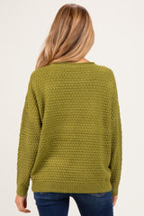 woman wearing a textured olive green maternity sweater, shown from the back with relaxed fit and long sleeves