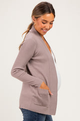 woman wearing a light brown ribbed maternity cardigan with pockets and a visible baby bump