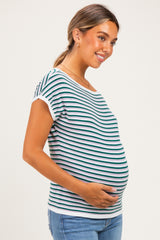 woman wearing a striped maternity top with green and white lines, showing her baby bump while smiling