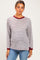 woman wearing a striped long sleeve maternity top with burgundy accents and light blue jeans