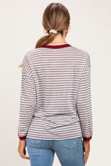 woman wearing a striped long sleeve maternity top with maroon accents and a round neckline, showing her back