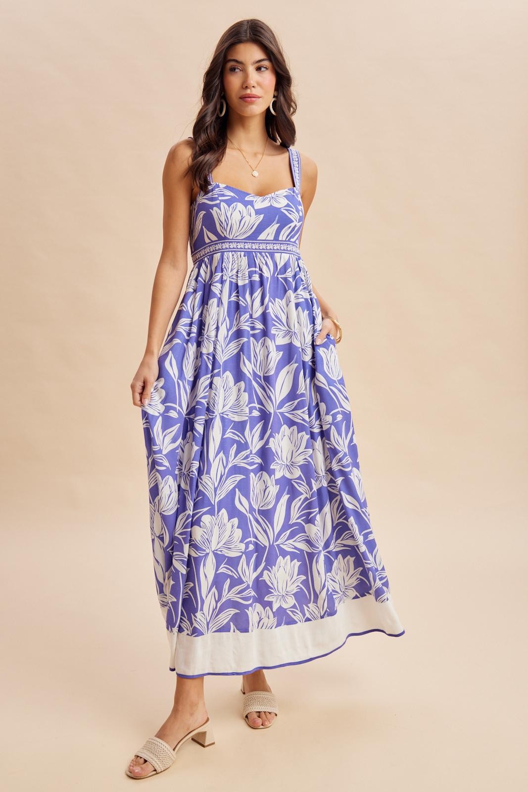 woman wearing a purple floral maxi dress with spaghetti straps and a fitted bodice