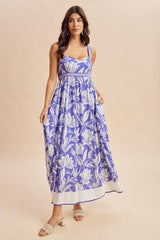 woman wearing a purple floral maxi dress with spaghetti straps and a fitted bodice