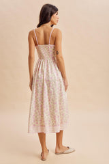 woman wearing a floral print midi dress with thin straps and a smocked back, viewed from behind