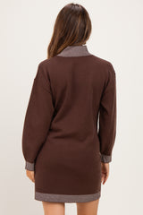 woman wearing a brown maternity sweater dress with a striped collar and cuffs, shown from the back