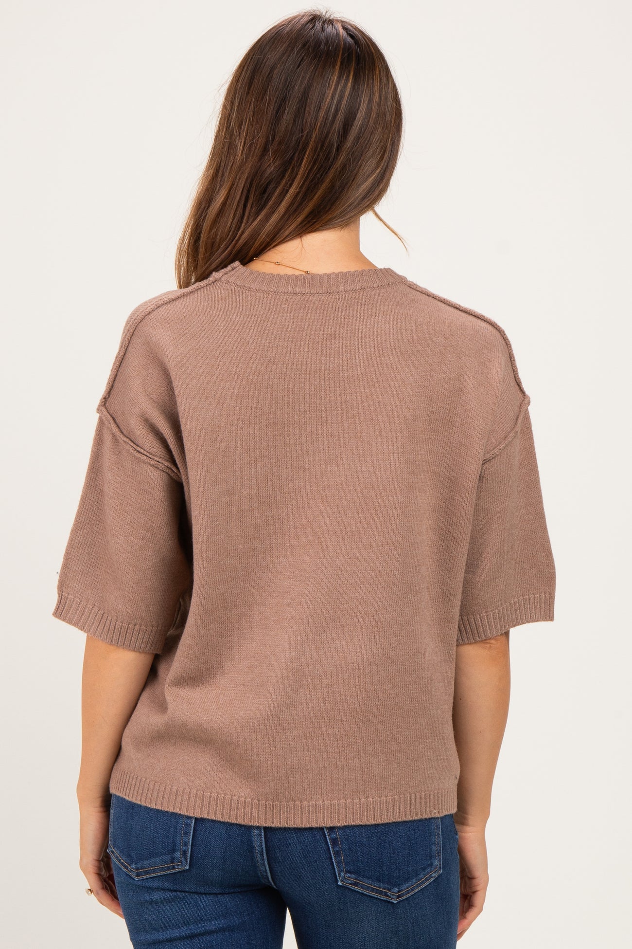 woman wearing a brown maternity sweater with short sleeves, seen from the back