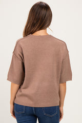 woman wearing a brown maternity sweater with short sleeves, seen from the back
