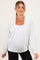 woman wearing a light grey maternity cardigan over a white tank top and showing her baby bump