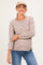 woman wearing a brown and cream striped maternity top with long sleeves and a relaxed fit, smiling and holding her baby bump