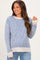 woman wearing a striped blue and cream maternity sweater with long sleeves and smiling