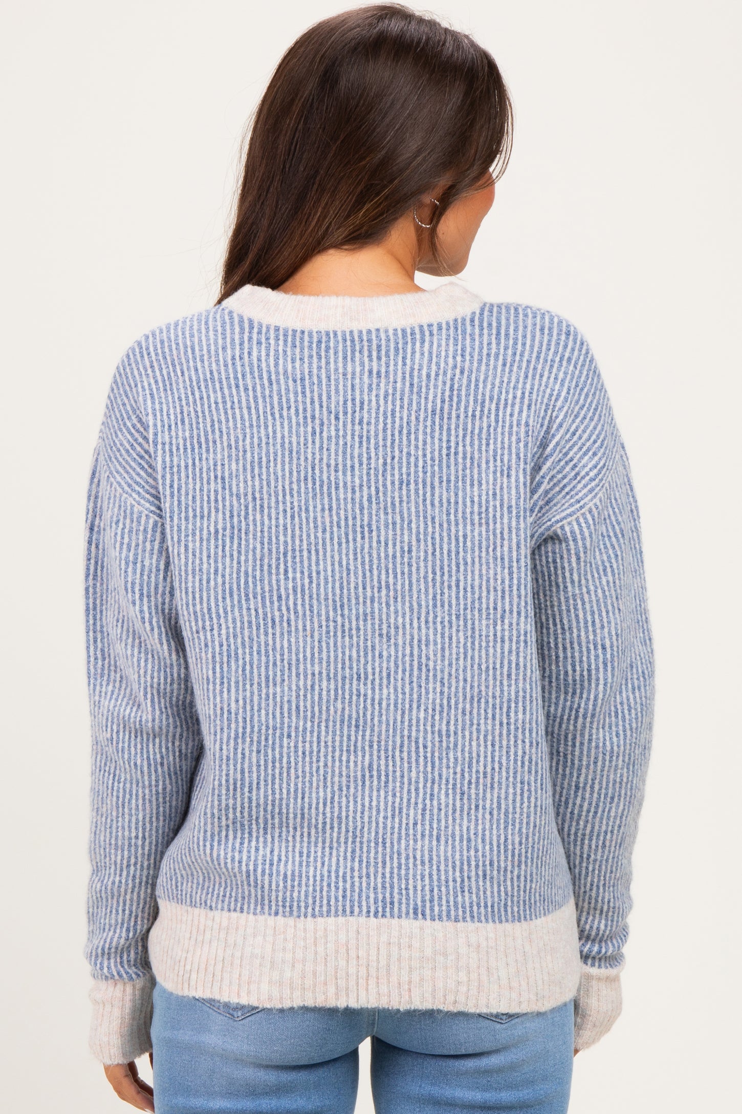 woman wearing a light blue and white striped maternity sweater, showing the back view