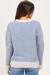 woman wearing a light blue and white striped maternity sweater, showing the back view