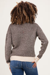 woman wearing a striped maternity sweater in brown and cream, with a relaxed fit, showing her back and wearing jeans