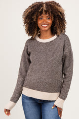 woman wearing a brown and cream striped maternity sweater with a relaxed fit and long sleeves