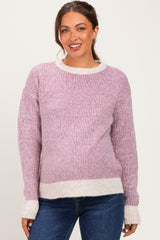 woman wearing a pink and white striped maternity sweater with a relaxed fit and ribbed texture