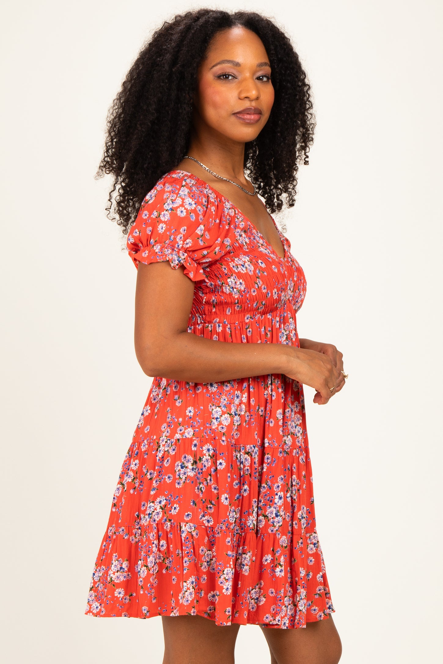woman wearing a red floral print short sleeve dress with a fitted bodice and flared skirt