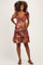 woman wearing a colorful patterned maternity dress with short sleeves and holding her baby bump