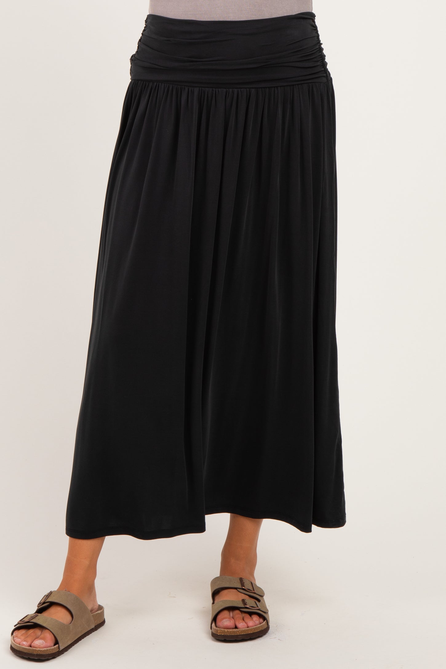woman wearing a black maternity maxi skirt with a gathered waist and a flowing silhouette