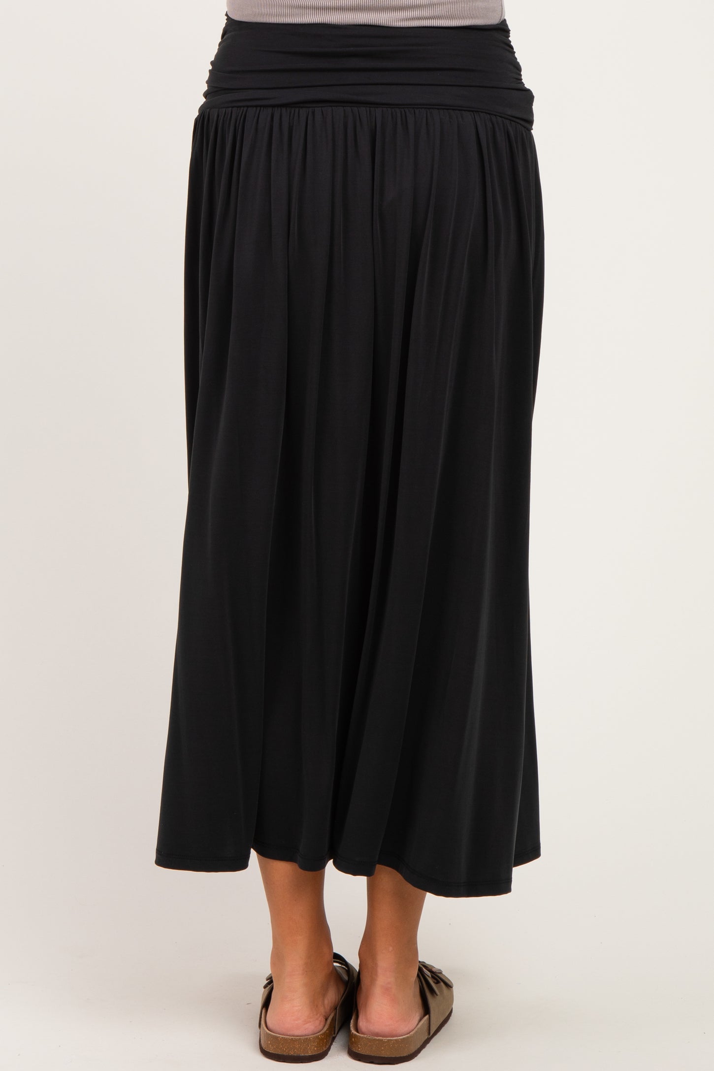 woman wearing a black maternity maxi skirt with a comfortable waistband and flowing silhouette, showing a baby bump