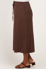 woman wearing a brown maternity maxi skirt with a drawstring waist, shown from the side