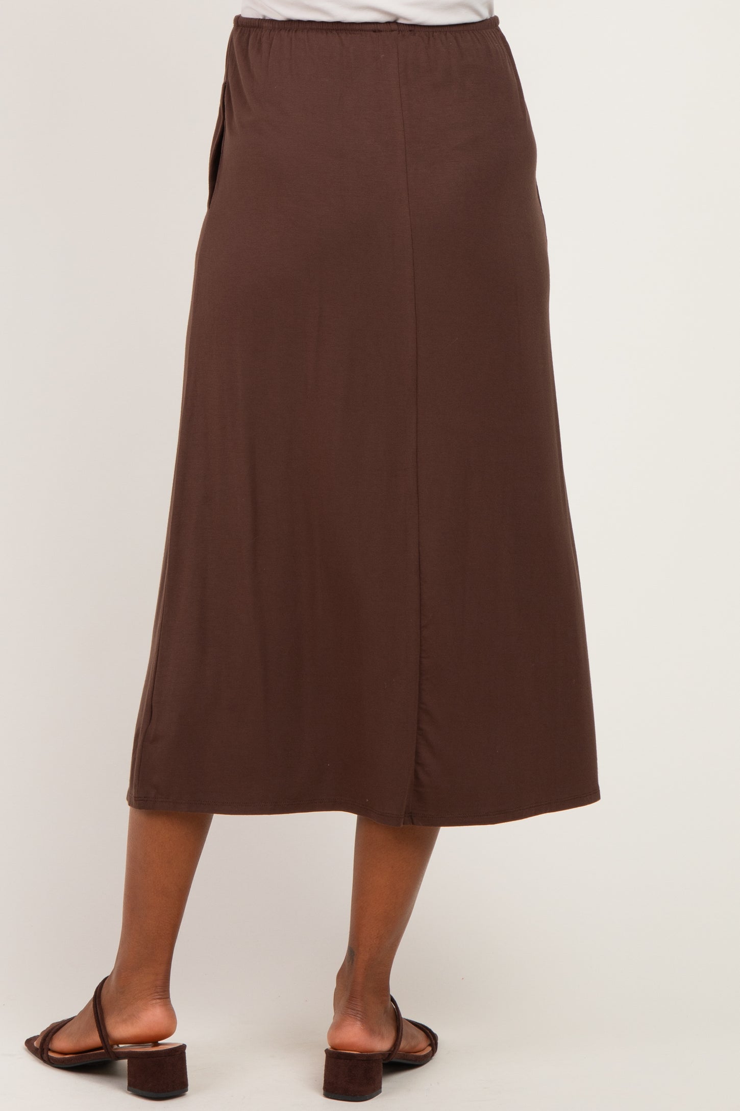 maternity wear brown midi skirt with an elastic waistband, model shown from the back wearing flat sandals
