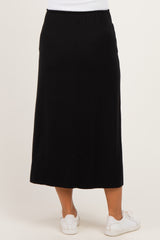 woman wearing a black maternity midi skirt with an elastic waistband and side slit, viewed from the back