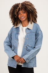 woman wearing a light blue denim maternity jacket with a beige collar and pockets, modeling with a baby bump visible